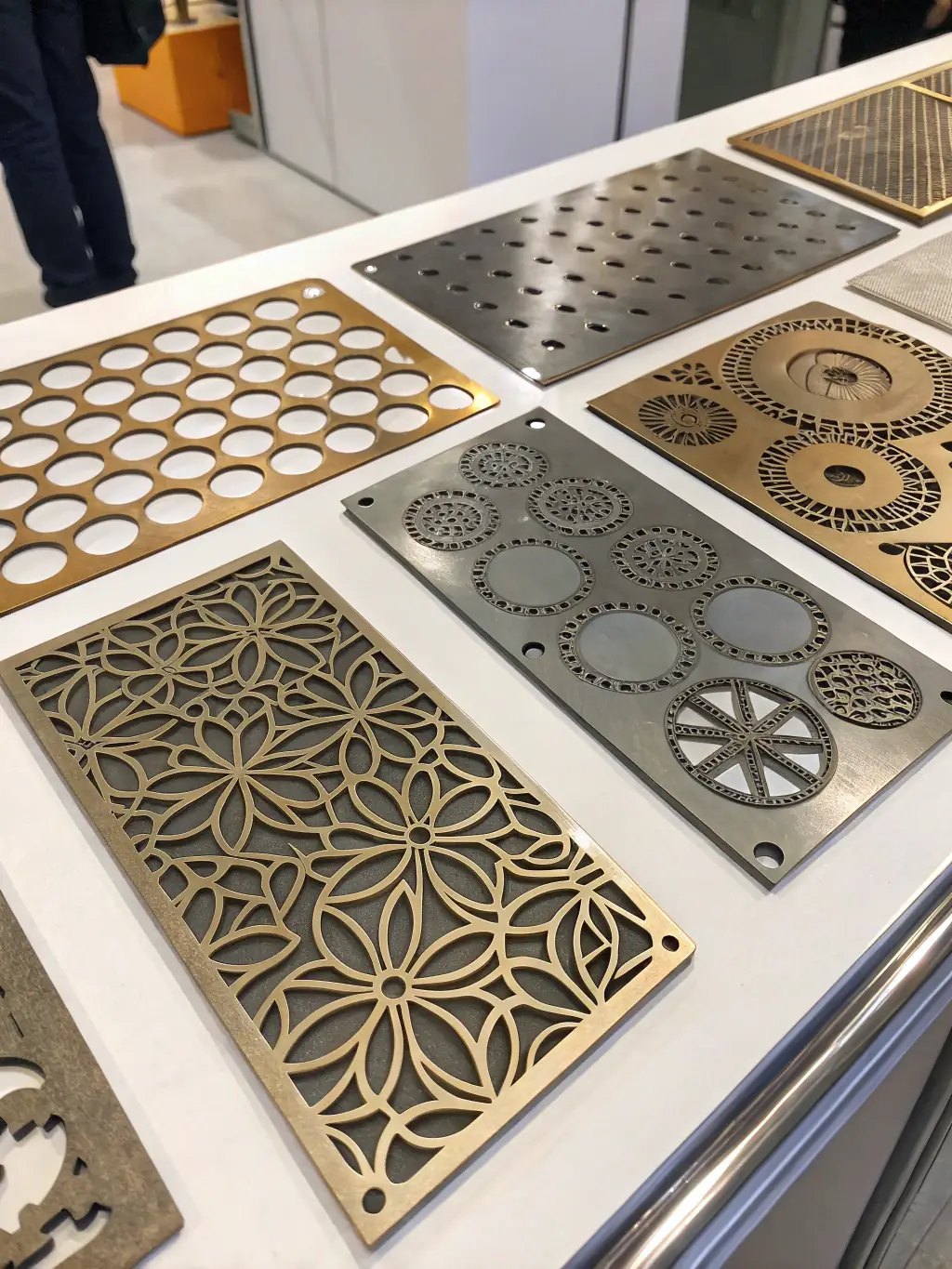 A close-up shot of various metal samples cut with CNC plasma technology, highlighting the smooth edges and intricate designs achievable.